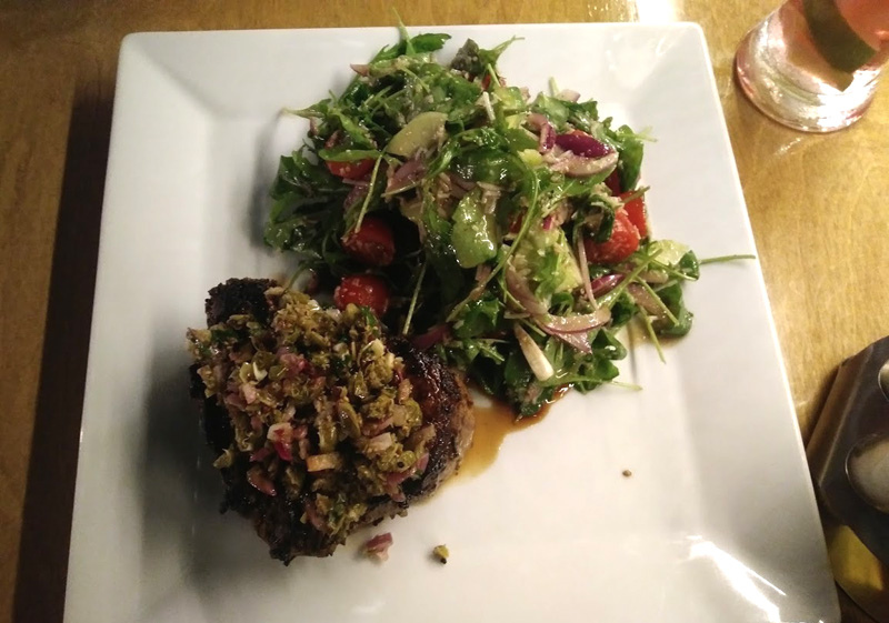 Stek serwowany z gremolatą ze świeżej natki pietruszki, sałatką z rukoli, pomidorem, cebulą, parmezanem z domowym sosem winegret